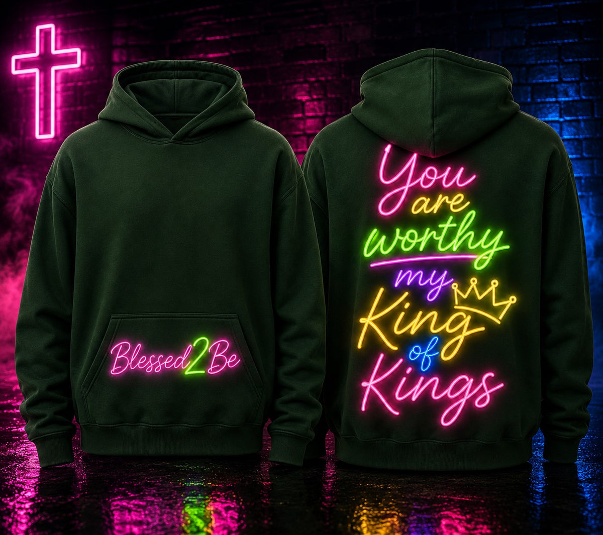 Two dark green hoodies shown front and back against a neon-lit brick wall. The front hoodie has pink and green 'Blessed2Be' text on the pocket area.
